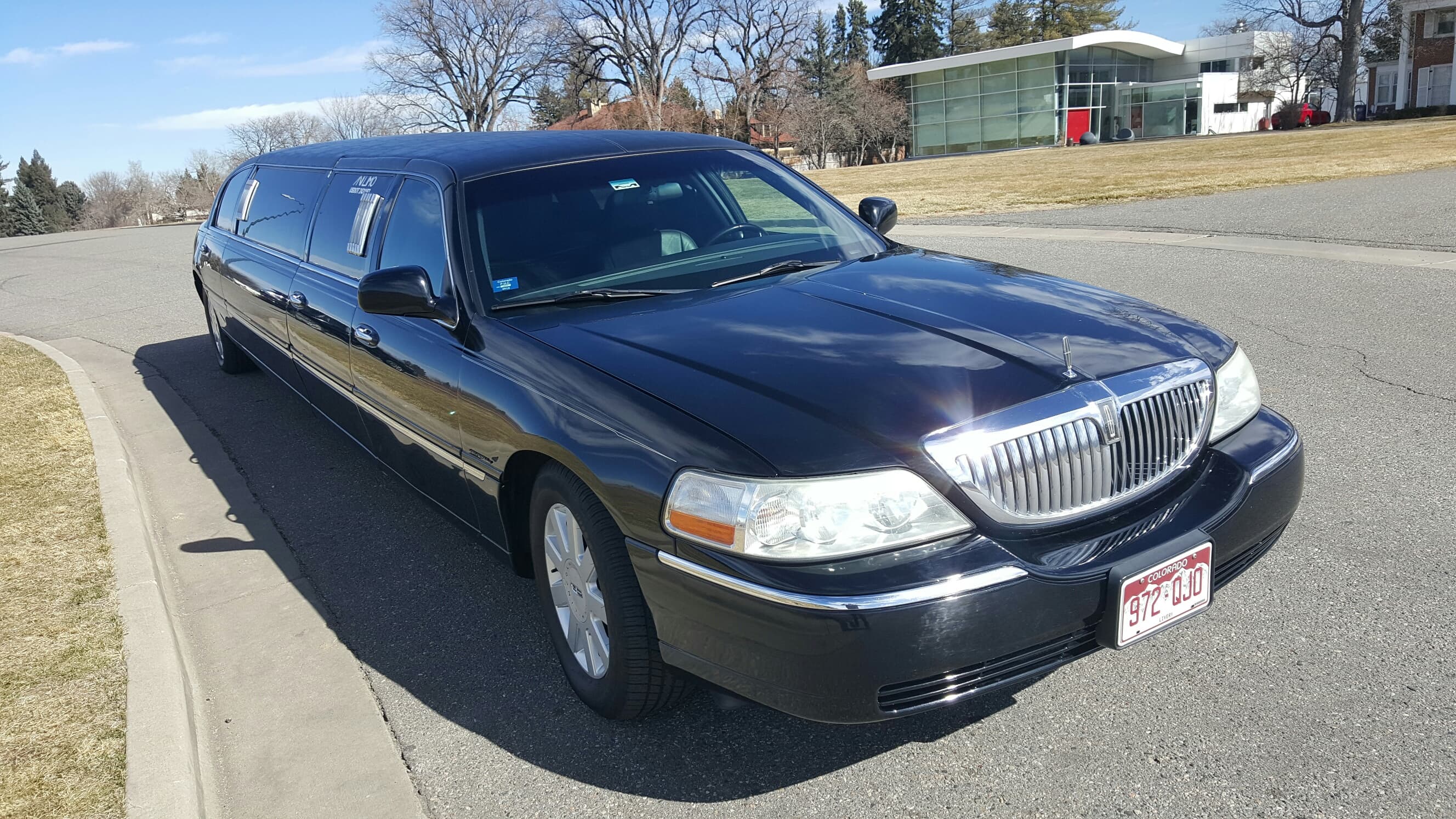 Avi Limo black stretch limousine parked on a Colorado drive