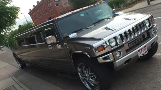 Charcoal Hummer stretch limousine from the Avi Limo fleet on a Denver street