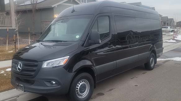 Black Mercedes-Benz Sprinter from the Avi Limo fleet on a Colorado street